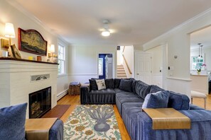 Ein Wohnzimmer mit Kamin, einem Ecksofa und einem gemusterten Teppich.
