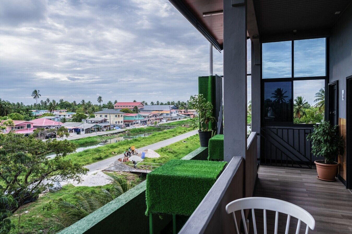 Ein Balkon mit Blick auf eine Wohngegend, einen kleinen Garten und Holzboden.