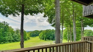 Une terrasse en bois offrant une vue sur un paysage boisé.