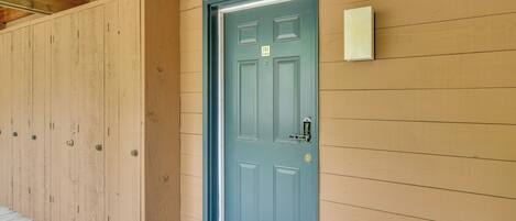 A wooden building with a blue door, a mailbox, and a wooden floor.