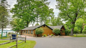A wooden cabin with a sloped roof, surrounded by a wooden fence and a paved driveway. - Near Slopes, Golf, Lake! Shanty Creek Resort Condo (Bellaire)