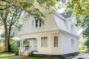 A two-story house with a porch, a front door, and a staircase leading to the entrance. - Mid-Term Stay in Mobile! Charming Retreat w/ Deck (Mobile)