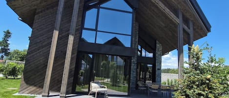 A modern building with a brick facade, large glass windows, and a paved entrance.