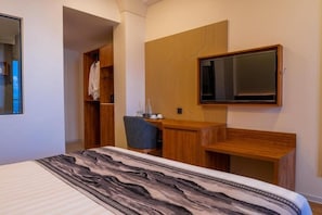 A bedroom with a bed, a desk, a chair, a wardrobe, and a television. - Triton Exotica (Maafushi)