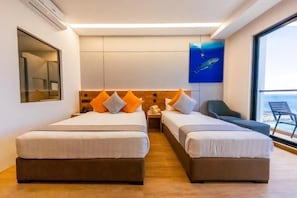 Una habitación de hotel con dos camas, un ventanal grande y un cuadro de una ballena.
