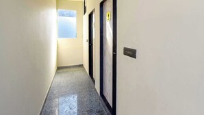 A hallway with doors, a window, and a light switch. - Palette Hotel Sun Royaale Udaipur (Udaipur)