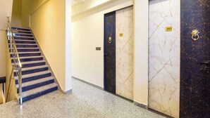 A modern interior with a staircase, marble walls, and numbered doors. - Palette Hotel Sun Royaale Udaipur (Udaipur)