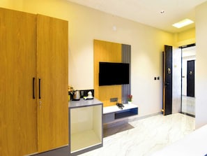A hotel room with wooden wardrobes, a flat-screen TV, a coffee station, and a marble floor. - Palette Hotel Sun Royaale Udaipur (Udaipur)
