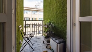 A balcony with a green wall, a folding chair, a small table, and a compact kitchen unit. - A bright, modern apartment, recently renovated with high-quality finishes and perfect for accommodating up to four people. The property is located in an elegant neighborhood in the heart of Turin, just 500 meters from Porta Nuova Station—offering direc (Turin)