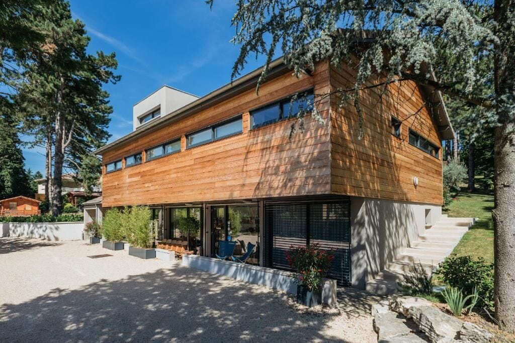 A modern two-story house with a wooden facade and large windows.