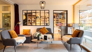 Una sala moderna con dos sillones, una mesa de centro y una estantería.