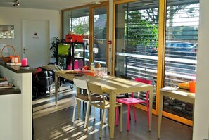 Una cocina moderna con comedor, ventanas amplias y vista a la calle.