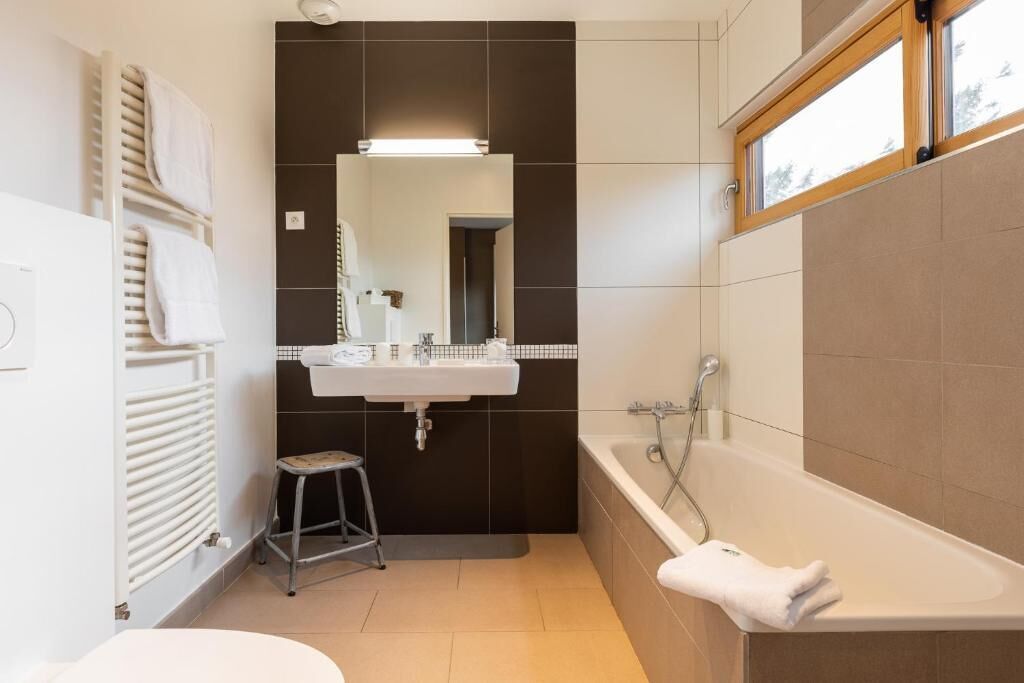Un baño moderno con bañera, lavamanos y espejo.