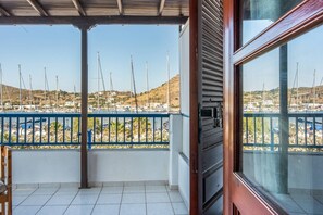 A balcony with a view of a marina, a tiled floor, and a wooden door frame. - Anastasia's 1 Apartment with Private Balcony and Sea View (Skala)