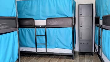 Un dormitorio con literas, un pequeño armario y suelo de baldosas.
