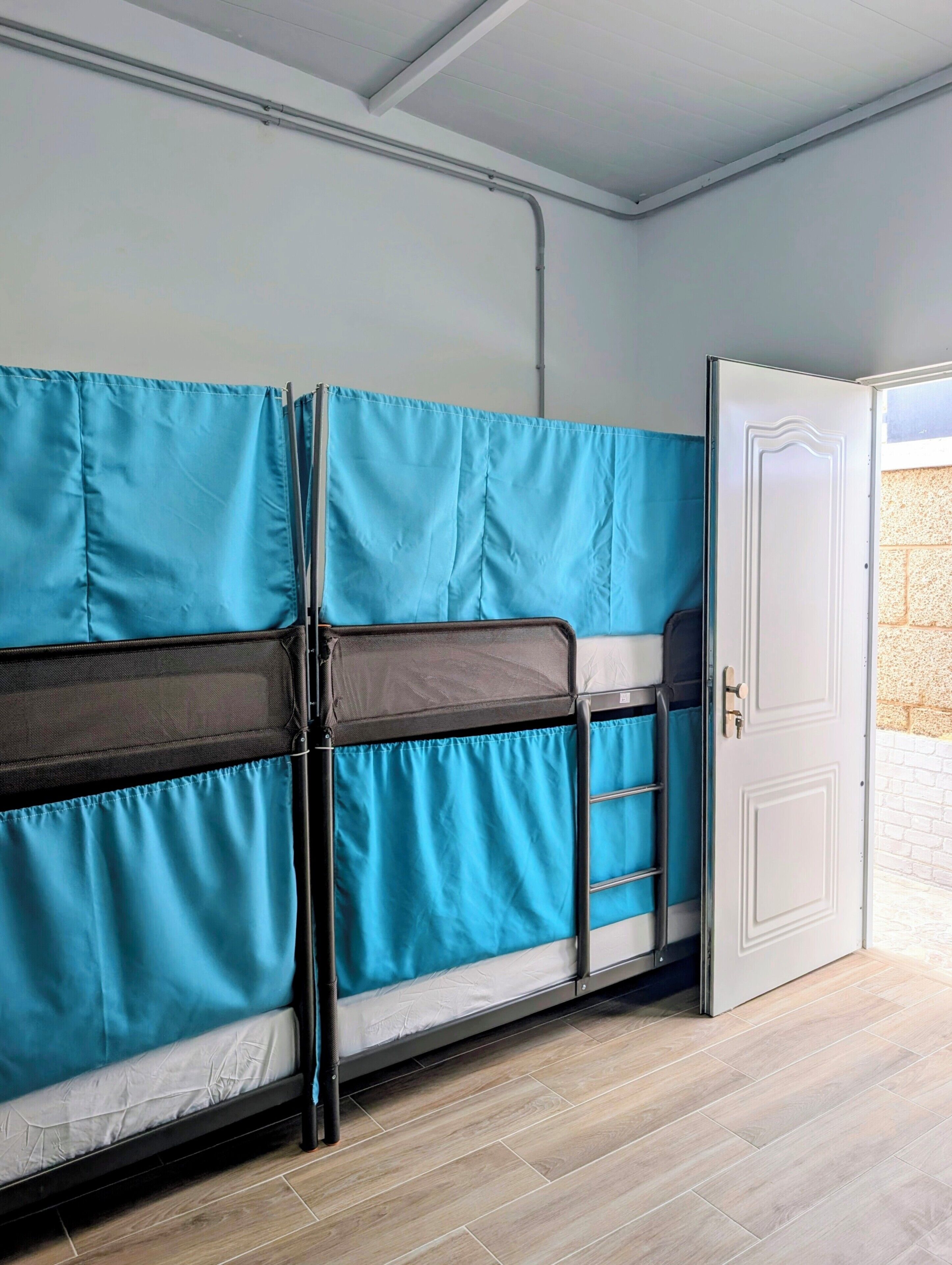 Una habitación con literas, una puerta y una ventana.
