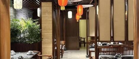 A restaurant interior with wooden furniture, tables, and hanging lanterns.