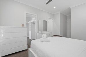 Une chambre d’hôtel comprenant un lit, une commode, un miroir et un dressing.