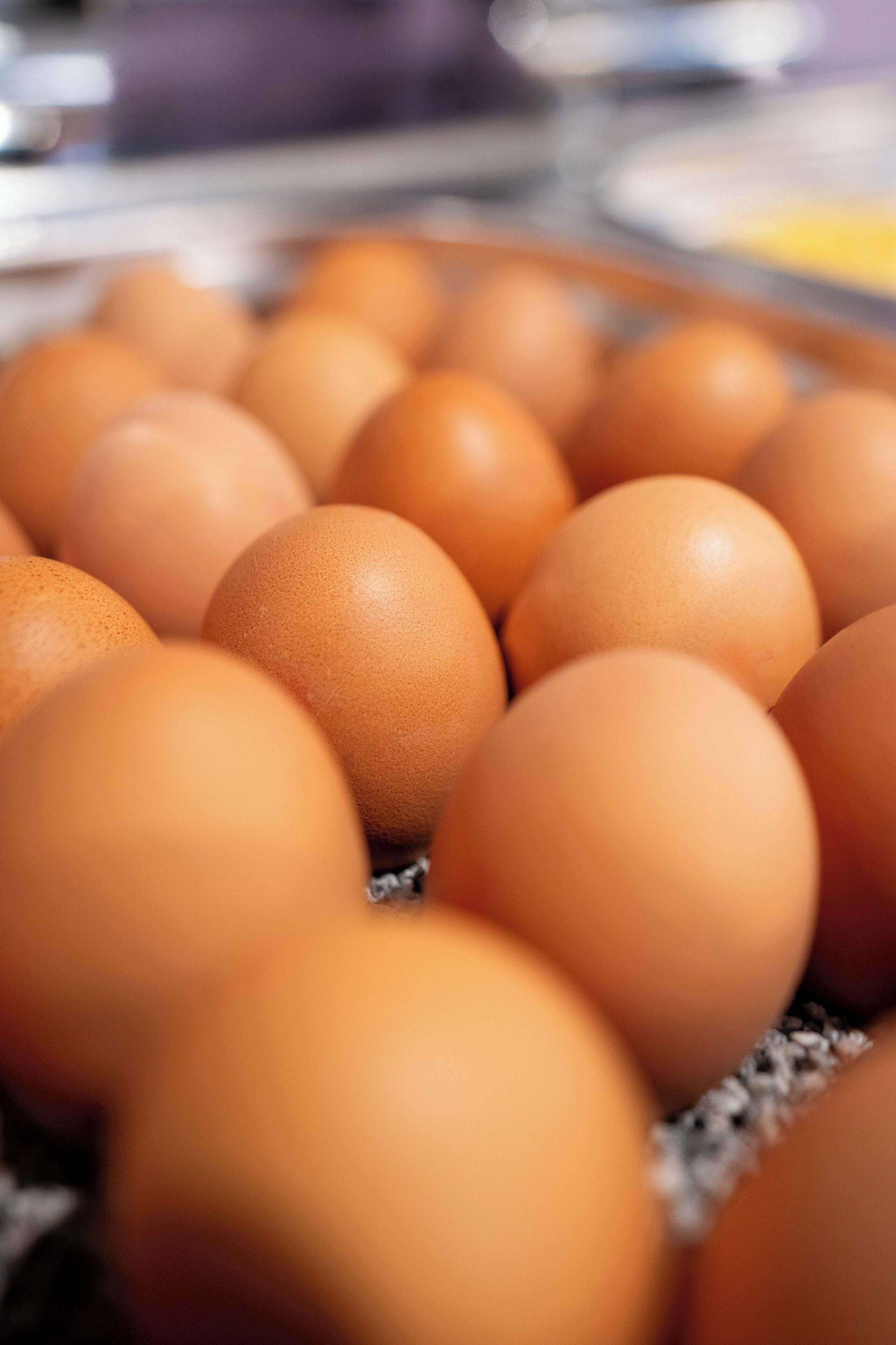 A close-up of several brown eggs in a carton.