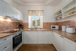 A kitchen with white cabinets, a window with curtains, a microwave, a toaster, and a coffee maker. - Villa Vinea (100691-K1) - Momjan (Momjan)
