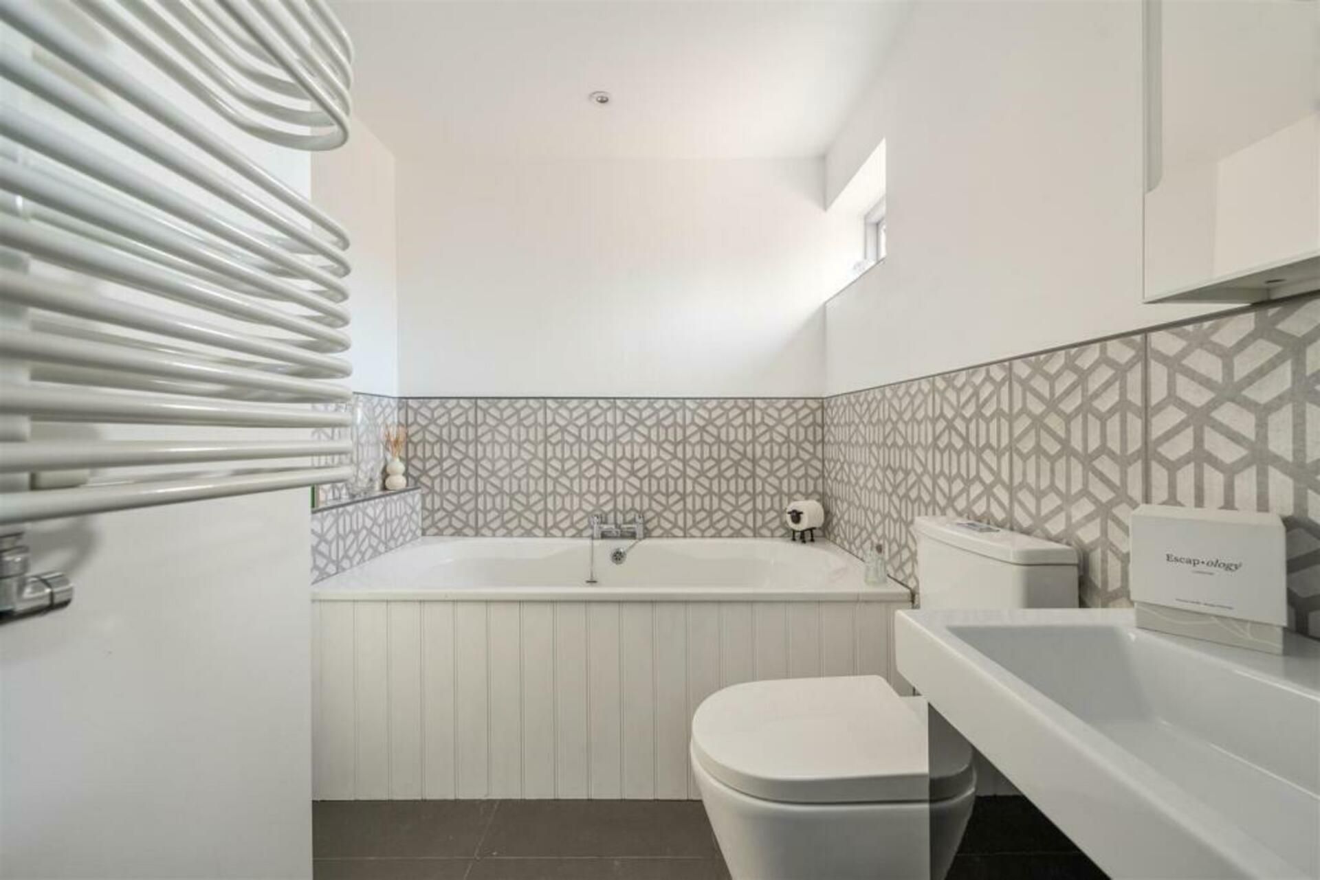 Un bagno moderno con vasca, water e lavabo.