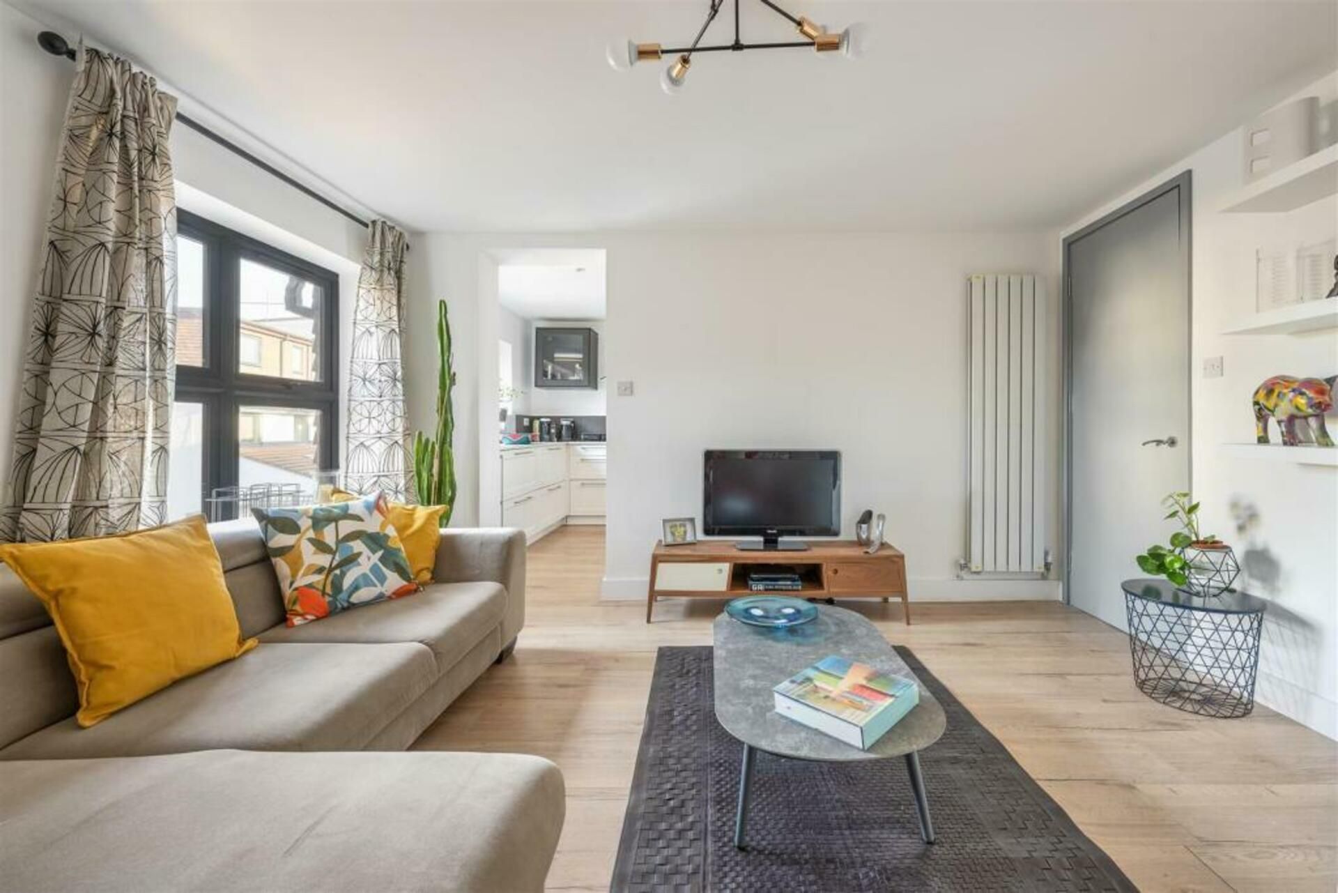 Un salon moderne avec un canapé, une table basse et un téléviseur à écran plat.