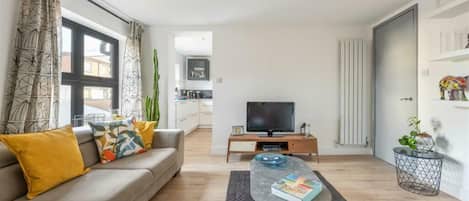 A modern living room with a sofa, coffee table, and a flat-screen TV.