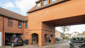 A residential building with a brick facade, a garage, and a covered driveway. - Contemporary 3BDR House in South Woodford (Greater London)
