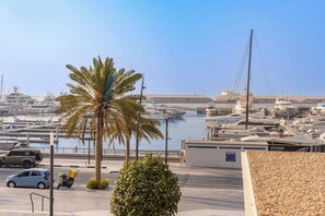 A marina with boats docked, a palm tree, and a clear sky. - StayShort - Stunning 2-Bedroom Apartment in Mina Rashid That Sleeps 6! (Dubai)