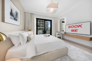 Et moderne hotelværelse med en stor seng, et fjernsyn og udsigt over byen.
