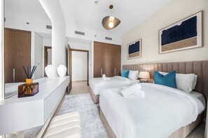 A hotel room with two beds, a large mirror, a desk, and a modern light fixture. - StayShort - Stunning 2-Bedroom Apartment in Mina Rashid That Sleeps 6! (Dubai)