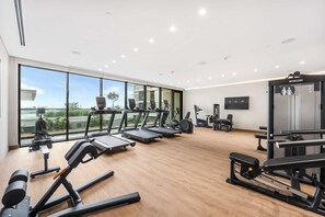 A modern gym with treadmills, elliptical machines, and weightlifting equipment. - StayShort - Stunning 2-Bedroom Apartment in Mina Rashid That Sleeps 6! (Dubai)