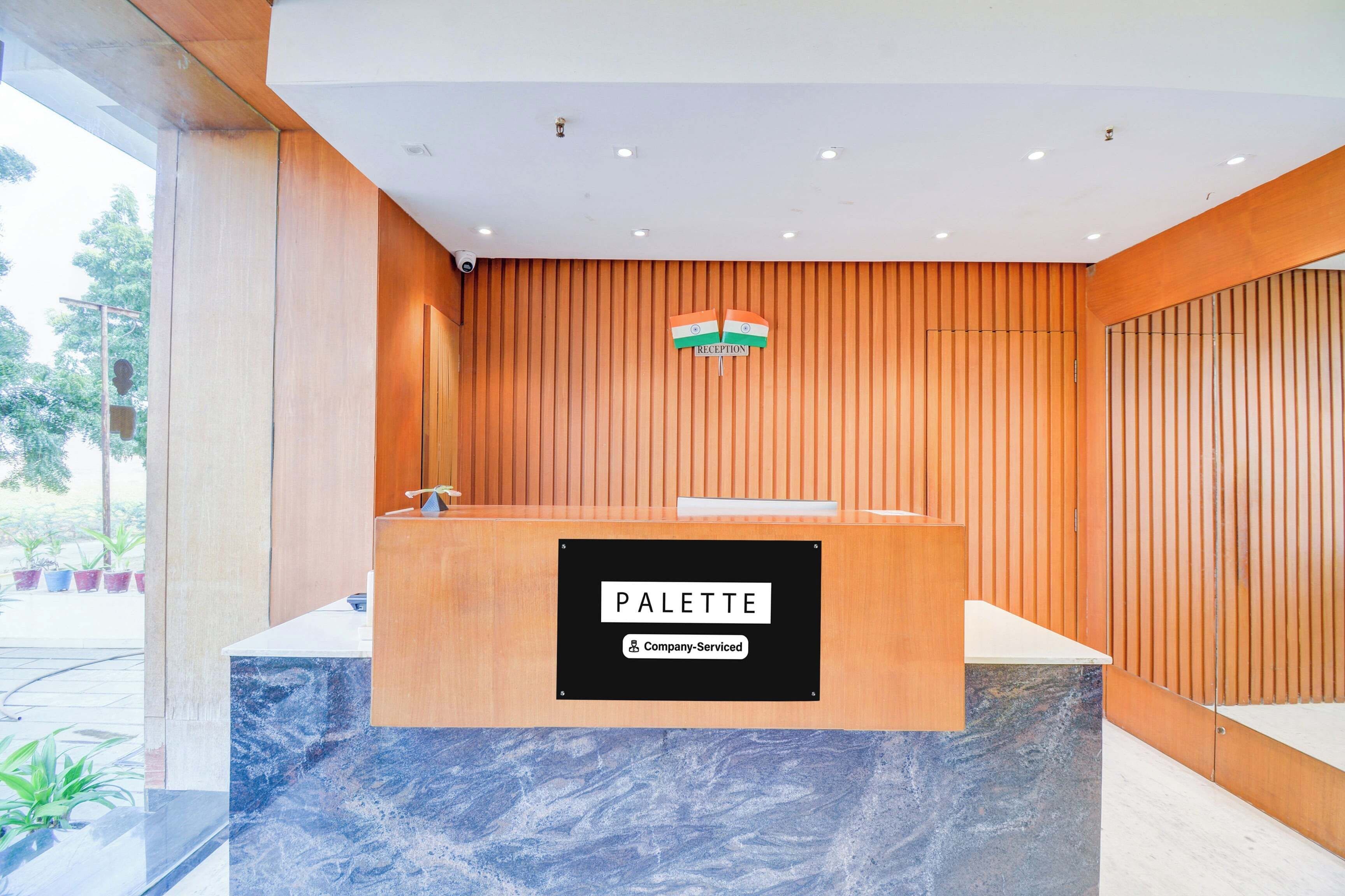 A reception desk with a sign indicating 'Reception' and 'PALETTE Company-Serviced.'