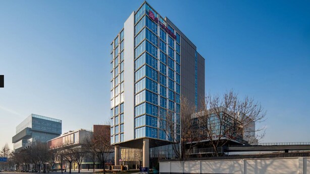 A modern multi-story building with a prominent signage at the top. - Hilton Garden Inn Beijing Fengtai Xiaotun Road (Beijing)