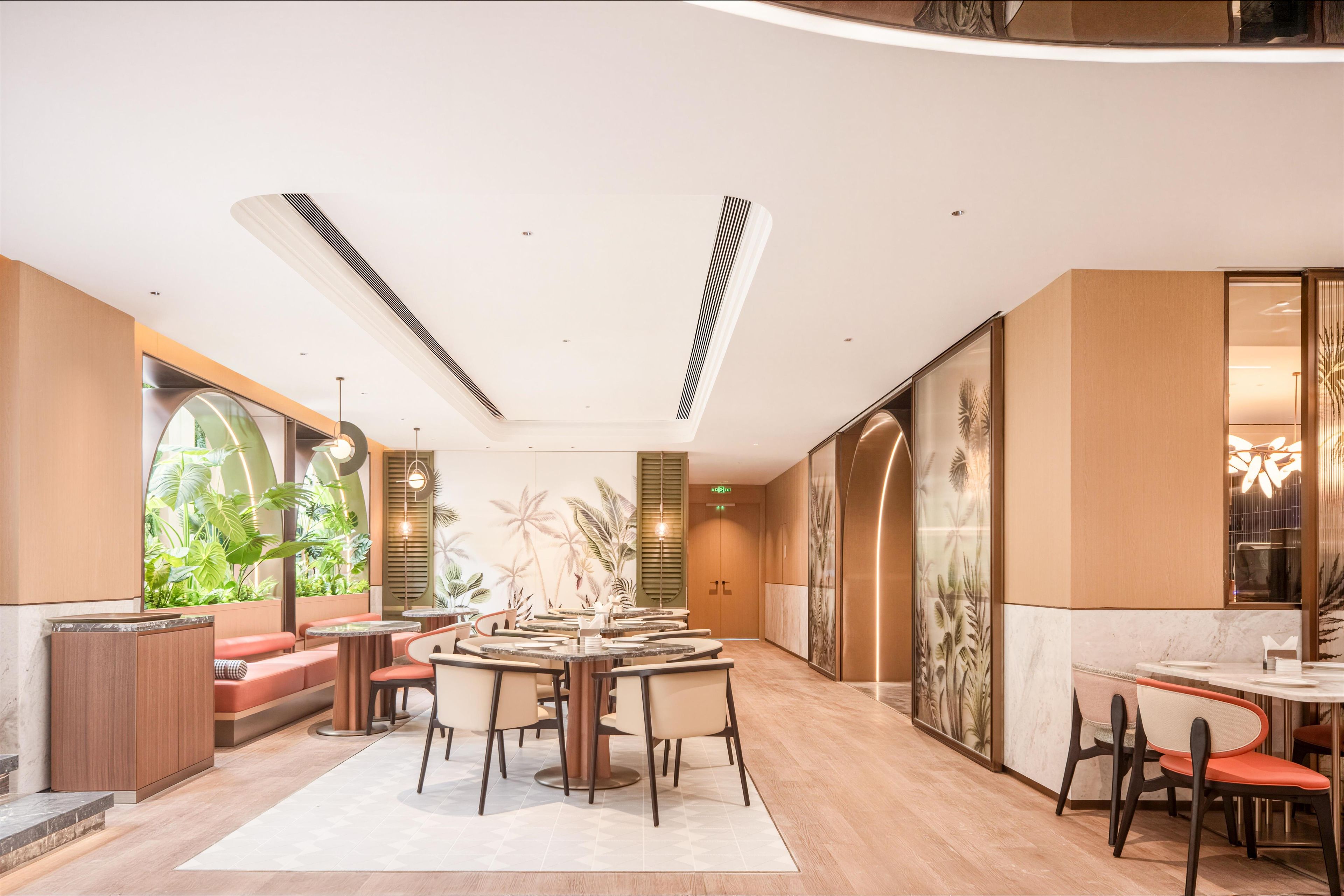 A modern interior with a central seating area, large windows, and a decorative wall.