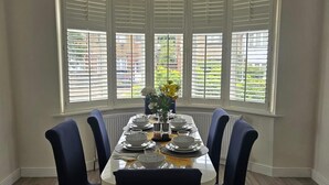 A dining room with a bay window, a chandelier, and a table set for six. - Home -near Town/lutonairport Sleeps 6/parking/wifi (Luton)
