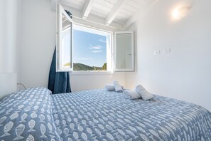 Une chambre à coucher avec un lit, une fenêtre et une vue sur l’extérieur.