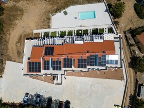 An aerial view of a building with a swimming pool, solar panels, and a fenced area. - Affittimoderni Trinità D'Agultu - Vacation Rental (Trinità d´Agultu e Vignola)