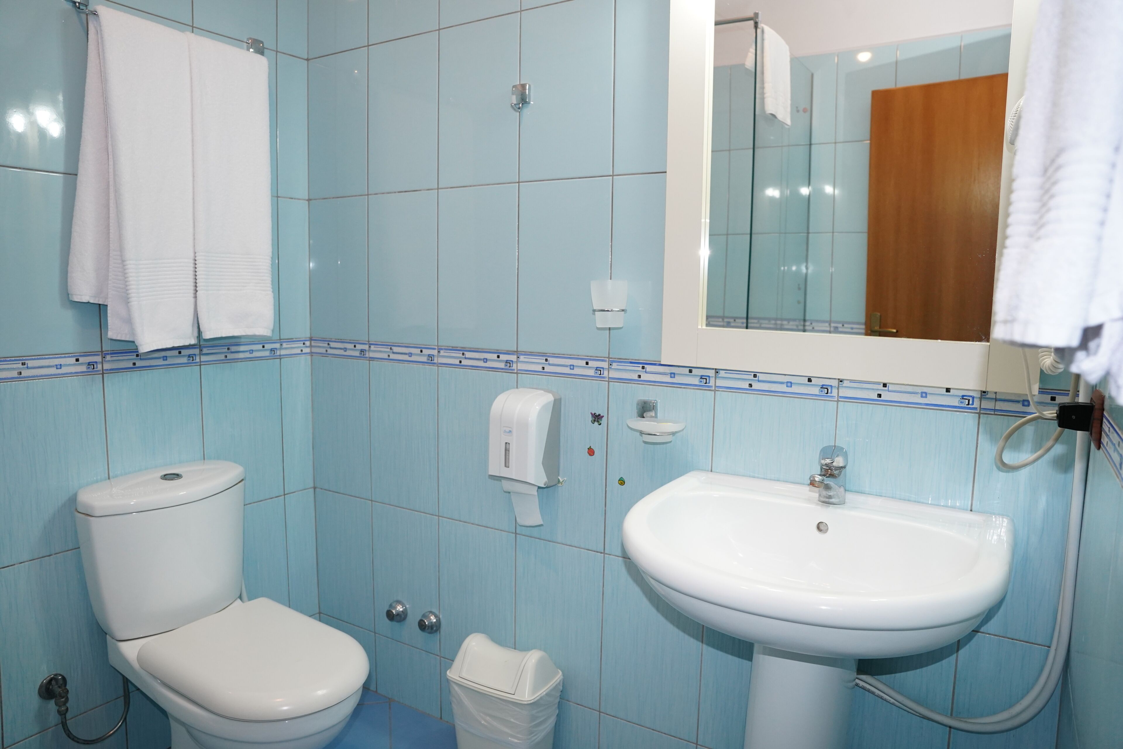 Un baño con inodoro, lavabo y espejo.
