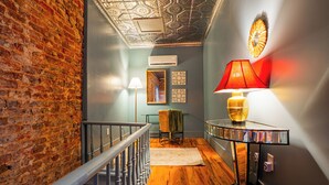 Eine Treppe mit einer Backsteinwand auf einer Seite, einem Holzboden und einer modernen Lampe auf der anderen.