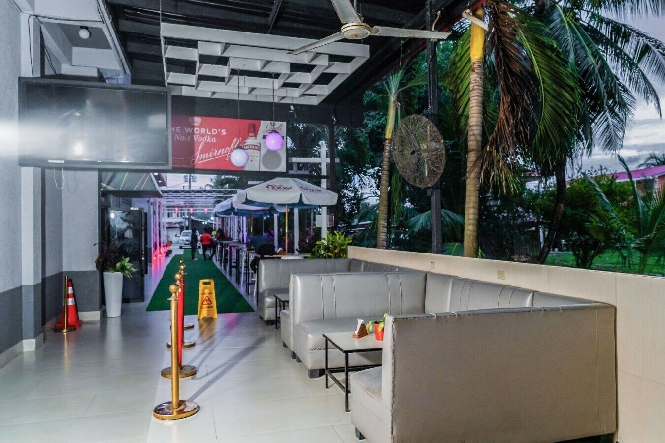 A hotel lobby with a reception desk, seating area, and a view of the outdoors.