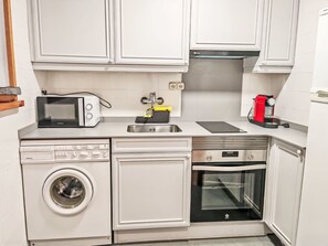 Eine kleine Küche mit Mikrowelle, Toaster, Spüle und kleinem Backofen.
