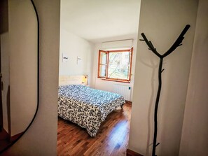 A bedroom with a bed, a window, a radiator, and a wooden floor. - Chimenea y modernidad-Dellui 3 by Interhome (Taüll)