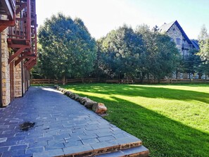 A paved pathway leading to a stone building with a wooden fence and trees in the background. - Chimenea y modernidad-Dellui 3 by Interhome (Taüll)