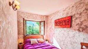 A narrow room with a bed, a window, and a wall-mounted artwork. - Apartamento - Puig Falcó 3 by Interhome (Taüll)
