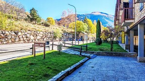 A paved pathway leading to a building with a stone wall and a sign that reads 'Edifici ERTA.' - Dúplex Luminoso - Erta 12 by Interhome (Taüll)