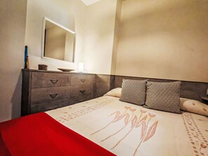 A bedroom with a bed, a dresser, a mirror, and a bedside table. - Herbasabina 2 con piscina by Interhome (Taüll)