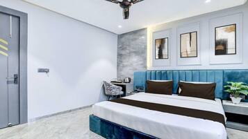 A modern bedroom with a bed, a ceiling fan, a nightstand, and a wall-mounted TV.