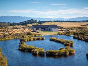 A lakeside property with a house, a dock, and a view of distant mountains.