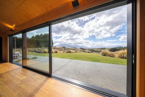 A modern interior with large sliding glass doors leading to a landscaped outdoor area.